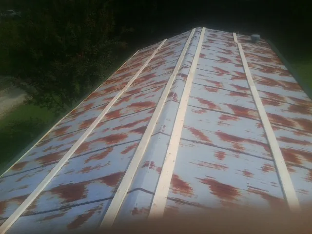 Rusted metal roof panels with new wood purlins before replacement — Storm Damage Roof Repair in Meyersdale by Roofing Brothers