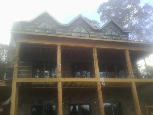 Dormers and porch framing on a large log home under construction — Roof Coating work by our crew in Meyersdale