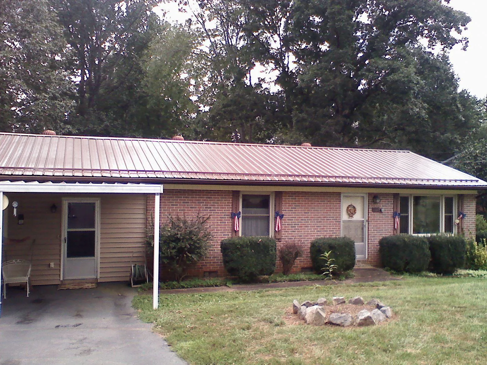 Bronze metal roof and carport on a brick ranch home — Roof Repair work by our crew in Meyersdale